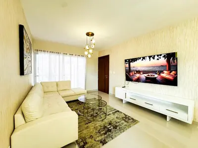 a living room with a white couch and a flat screen tv at Serene Penthouse near Homs Hospital in El Ejido