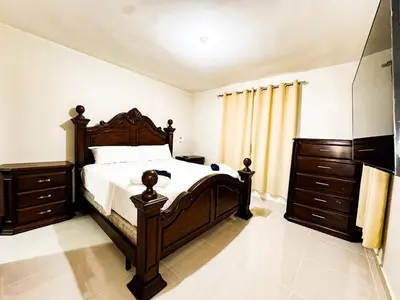 a bedroom with a large bed and wooden furniture at Serene Penthouse near Homs Hospital in El Ejido