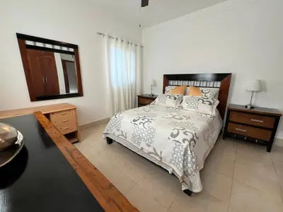 a bedroom with a bed and a dresser and a mirror at Caribbean luxury in Sosúa