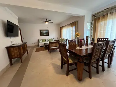a dining room with a table and chairs and a couch at Caribbean luxury in Sosúa