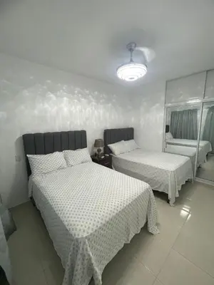 a bedroom with two beds and a chair in it at Byk 2 in Nagua