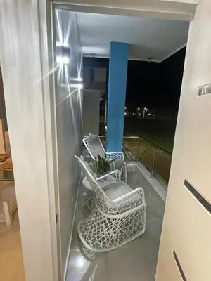a balcony with two chairs and a blue pole at Byk 2 in Nagua