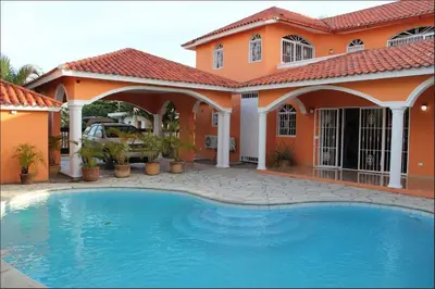 a house with a swimming pool in front of it at Villa Tropical Cabarete in Sosua