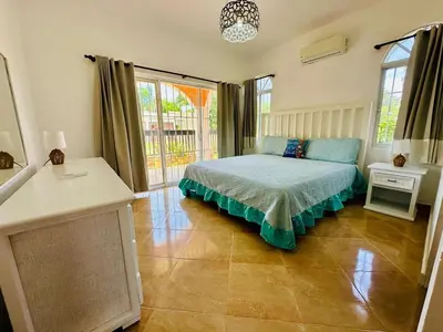 a bedroom with a bed and a large window at Villa Tropical Cabarete in Sosua