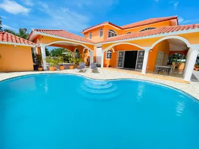 a swimming pool in front of a house at Villa Tropical Cabarete in Sosua
