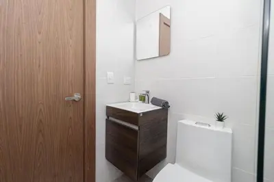 a bathroom with a toilet and a sink and a door at Elegant Coastal Escape Spacious 2BR Bayahibe in San Rafael del Yuma