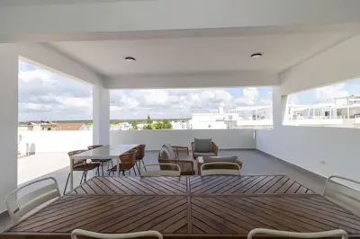a living room with a table and chairs on a balcony at Elegant Coastal Escape Spacious 2BR Bayahibe in San Rafael del Yuma