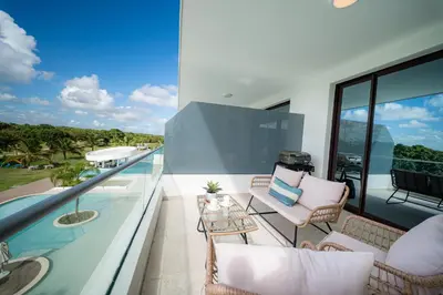 a balcony with a view of the ocean from a house at Vista Velero – 1BR Coastal Escape @ Cana Rock Star in Punta Cana