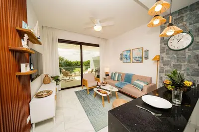 a kitchen and living room with a clock on the wall at Vista Velero – 1BR Coastal Escape @ Cana Rock Star in Punta Cana