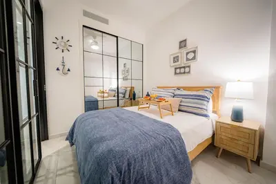 a bedroom with a bed and a table with a clock on the wall at Vista Velero – 1BR Coastal Escape @ Cana Rock Star in Punta Cana