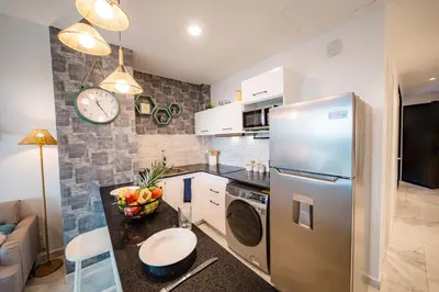 a kitchen with a stainless steel refrigerator and a microwave at Vista Velero – 1BR Coastal Escape @ Cana Rock Star in Punta Cana