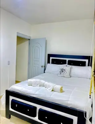 a large white bed with two towels on it at Apartment with Everything AC Wifi and Solar panel in Bonao