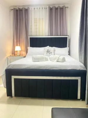 a bed with a blue frame and white sheets and pillows at Apartment with Everything AC Wifi and Solar panel in Bonao