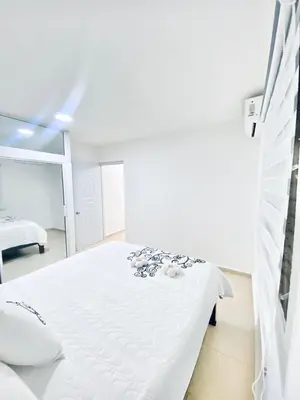 a white bedroom with a white bed in it at Centrally located Comfortable Apartment in Bonao