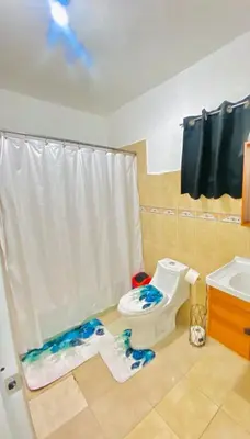 a bathroom with a toilet and a sink at Centrally located Comfortable Apartment in Bonao