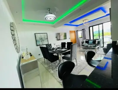 a dining room and living room with a table and chairs at Tranquilo y acogedor in Santiago de los Caballeros