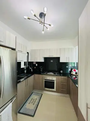 a kitchen with white cabinets and a stainless steel refrigerator at Tranquilo y acogedor in Santiago de los Caballeros