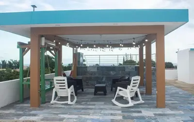 a pavilion with white chairs and a blue roof at Byk in Nagua