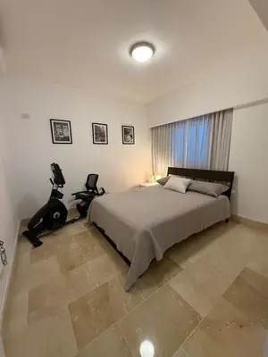 a bedroom with a bed and two chairs in it at Luxury 3 Rooms Apartment in SDO with Carribean Sea View in Santo Domingo