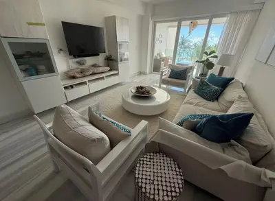 a living room with a couch and chairs and a tv at Seawinds Beachfront -Top Floor Less Mosquitos -Full Security in Cabarete