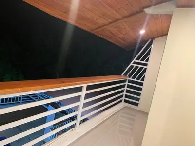 a balcony with a wooden roof at night at Villa Palmera Barahona, Dream Getaway in Santa Cruz de Barahona