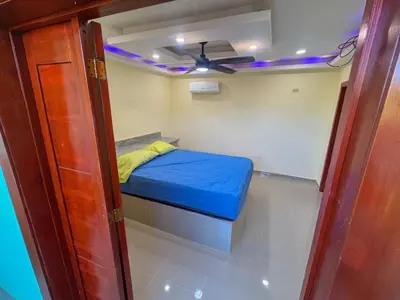 a small bed in a room with a ceiling fan at Villa Palmera Barahona, Dream Getaway in Santa Cruz de Barahona
