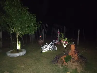 a white bike parked in a yard at night at Mi casita de Campo en Bayaguana in Bayaguana