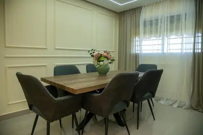 a dining room table with chairs and a vase of flowers at Casa Rosario in La Grúa