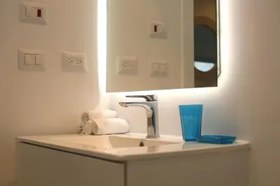 a white bathroom with a sink and a mirror at 1BRM Infinity Homes Punta Cana in Punta Cana