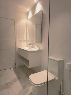a white bathroom with a toilet and a sink at 1BRM Infinity Homes Punta Cana in Punta Cana