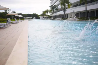a swimming pool with a fountain in front of a building at 1BRM Infinity Homes Punta Cana in Punta Cana