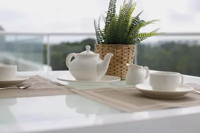a table with cups and saucers and a plant at 1BRM Infinity Homes Punta Cana in Punta Cana