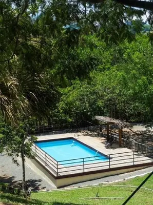a large swimming pool in a yard with trees at Villa María 2 in Bonao