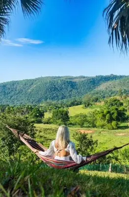 a woman laying in a hammock in a field at Villa María 2 in Bonao