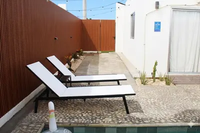 two white benches sitting next to a red fence at Casaè Rojas Presents Golden Oasis in Punta Cana