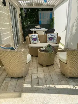 a patio with wicker chairs and a table on a patio at Apartamento en Santo Domingo in Los Mameyes