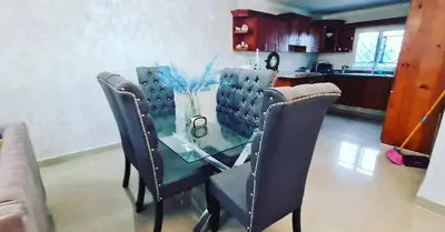 a glass table with chairs and a vase of flowers on it at Apartamento en Santo Domingo in Los Mameyes
