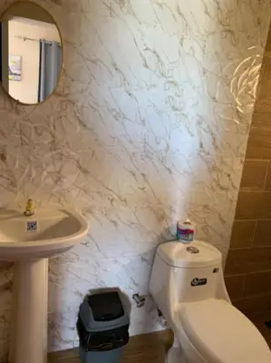 a bathroom with a toilet and a sink and a mirror at Hotel los 4 Tesoros in Pedernales