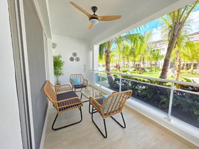 a porch with chairs and a large window with palm trees at Estrella Garden Shaula 104 New Modern Apartment in La Laguna
