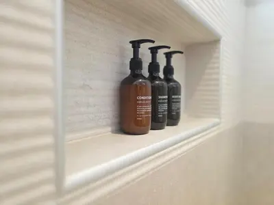 three bottles of liquid sitting on a shelf in a bathroom at Estrella Garden Shaula 104 New Modern Apartment in La Laguna