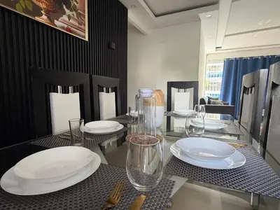 a dining table with white plates and glasses on it at Vacaciones809 in Juan López