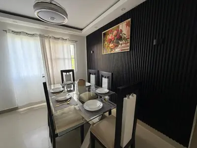a dining room with a glass table and chairs at Vacaciones809 in Juan López