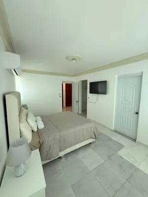 a bedroom with a bed and a flat screen tv at Residencial Marvin I Apartamento 1A in Santiago de los Caballeros