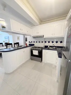 a white kitchen with white cabinets and black appliances at Residencial Marvin I Apartamento 1A in Santiago de los Caballeros
