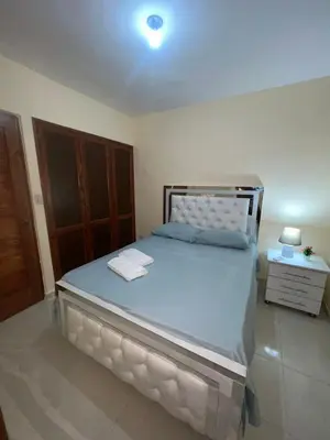 a bedroom with a large bed with a wooden cabinet at Los manglares in La Cana