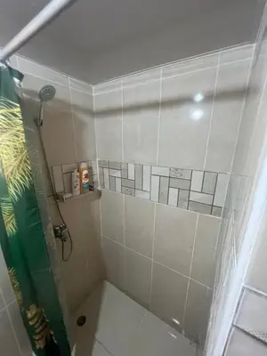 a bathroom with a shower with white tile at Los manglares in La Cana