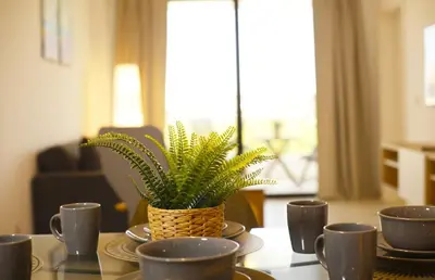 a table with cups and a potted plant on it at Exclusive 2BR Apartment Punta Cana in Punta Cana