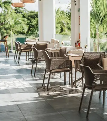 a row of tables and chairs in a restaurant at Exclusive 2BR Apartment Punta Cana in Punta Cana