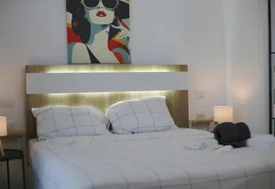 a bedroom with a large white bed with a painting at Exclusive 2BR Apartment Punta Cana in Punta Cana