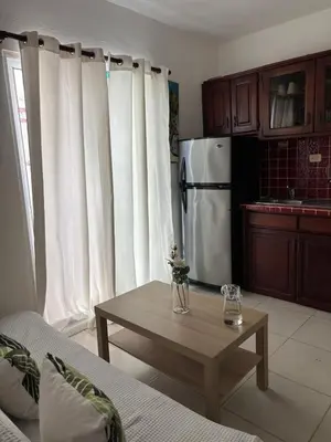 a kitchen with a coffee table and a refrigerator at Casa Bonita by Mireya in Bayahibe